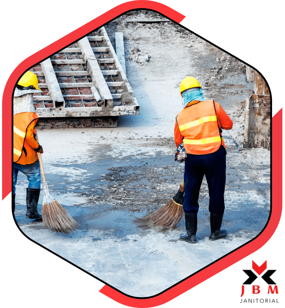 Construction cleaning professionals sweeping debris at a job site, providing post-construction cleaning services for a safe and tidy work environment.