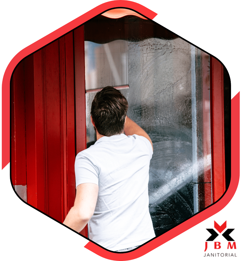 Tailored cleaning services expert cleaning a commercial window, offering customized cleaning solutions for businesses to maintain a pristine and professional appearance.