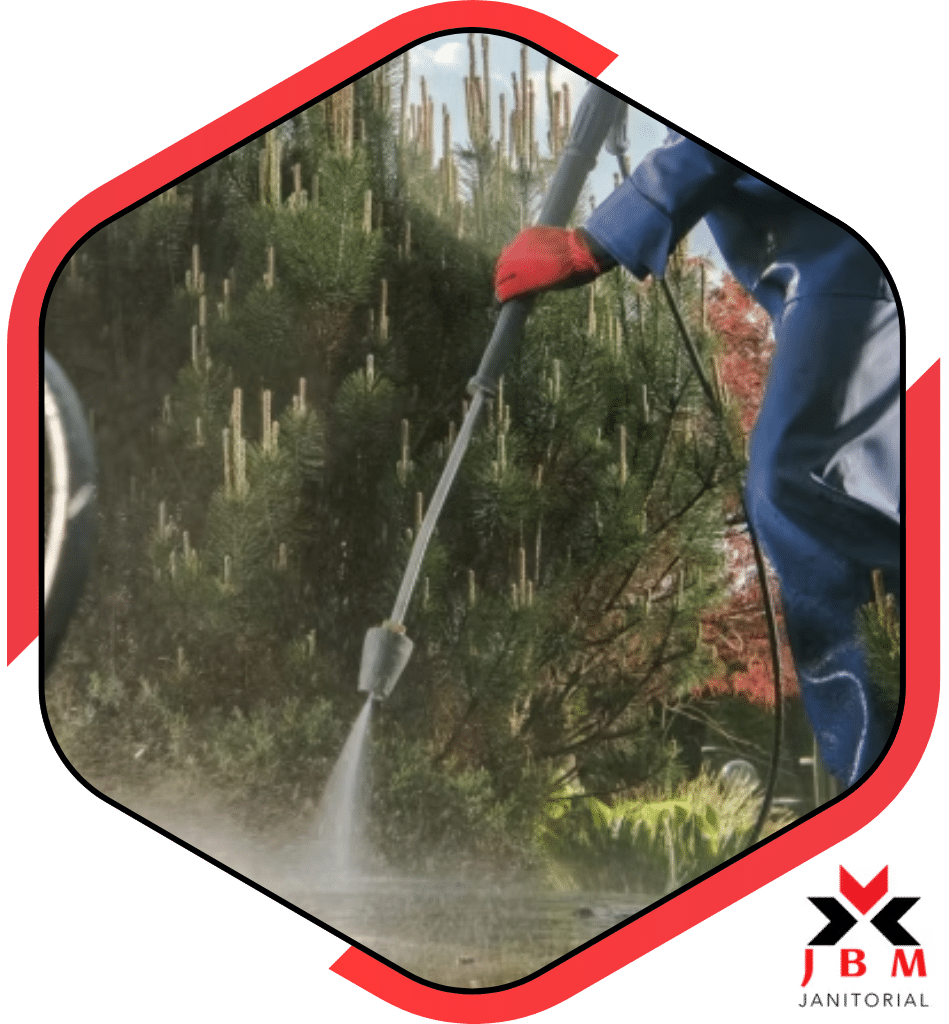 Commercial power washing professional using a pressure washer to clean outdoor surfaces, transforming business exteriors and improving curb appeal with expert cleaning services.