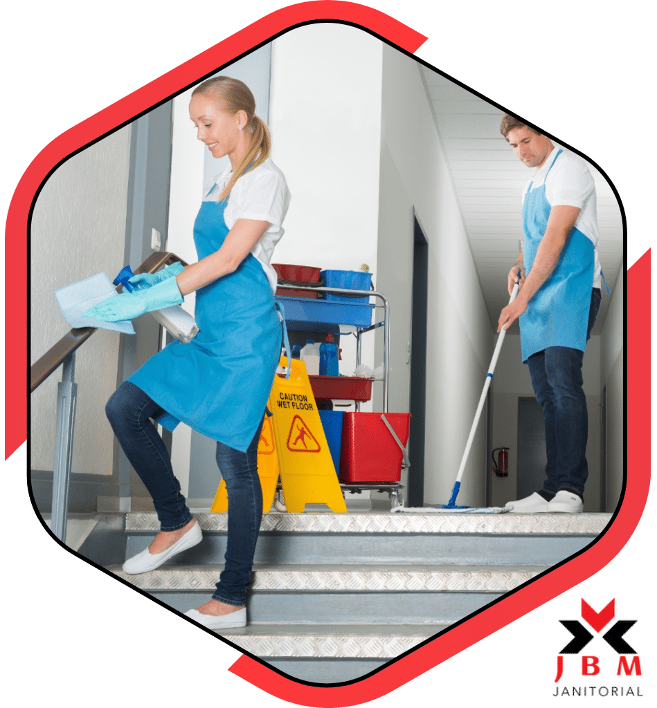 Trusted school cleaning service company cleaning a staircase with a wet mop and disinfecting handrails, ensuring a clean and safe environment for students and staff.