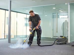 Vacuum cleaning in a large office to prevent dust build-up and maintain a clean, healthy environment.