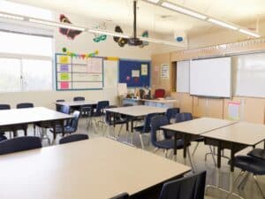 Empty classroom with desks and chairs, highlighting the potential for bacteria in school bathrooms.