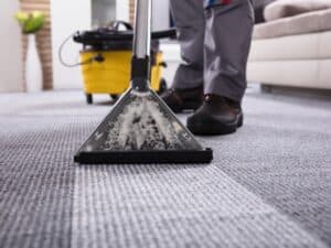 Person using steam cleaner to clean smelly carpet in office setting
